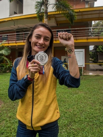 Sandra Lorena Arenas enseñando la medalla de plata